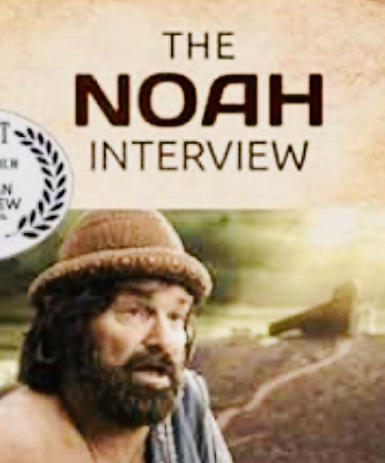 Close frame from The Noah Interview: the knit cap low on his brow, the ark soft on the ridge behind him.